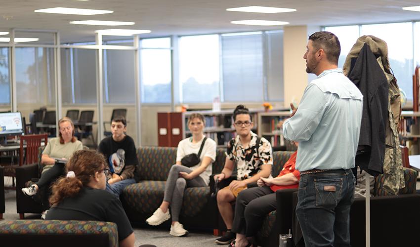 Tyler Froberg standing in front of the audience giving his presentation.