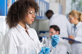 Pharmacy Technician measuring liquid medication